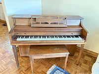 Front view of Mason & Risch upright piano with bench