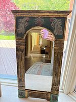 Front view of wood gilt mirror showing carved details and mirror glass