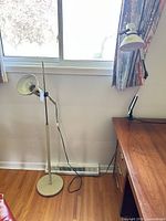 Floor and table lamps positioned by window and desk