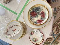 Stack of pierced dish over fruit plates, charger with rose plates
