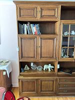 Front view of wall unit showing cabinets, shelves, glass door, drawers