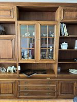 Front view of Castle Furniture wall unit showing glass doors, shelving, drawers, and cabinets