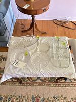 All items laid out on towel: oval platter, compote bowl, round plates, stack of small plates, divided trays