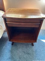 Front view showing drawer, open shelf, tapered legs