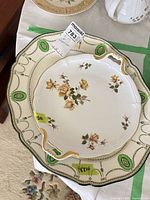 Two stacked porcelain platters showing overall designs and size labels