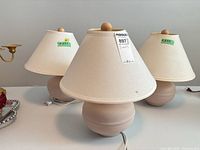 Three matching table lamps showing shades, bases and finials