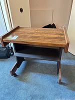 Front view showing walnut veneer top, open shelf, casters