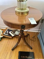 Full view of round pedestal end table with drawer and legs