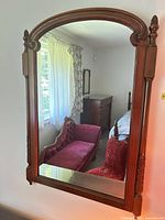 Front view of wall mirror showing full wooden frame and arched top