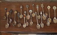 Full set of 18 souvenir spoons on tabletop