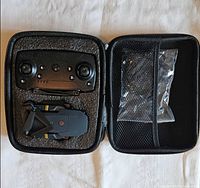 Drone, remote controller and accessories inside open foam-lined case