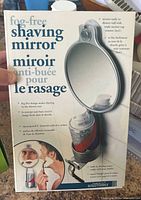 Front of retail package showing fog-free shaving mirror, caddy and razor holder features