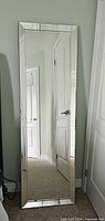 Front view of full length mirror showing mirrored beveled frame