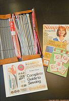 Open case showing multiple knitting needles and three craft books