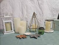 Group shot of all lanterns, candles and leaf dishes on table