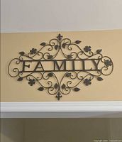 Full view of metal FAMILY wall art hanging on wall