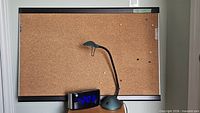 Cork bulletin board with lamp and clock displayed