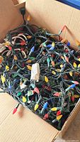 Box containing tangled multicolor outdoor Christmas light strands