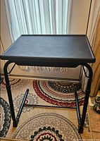 front view of black adjustable couch table showing tabletop and frame
