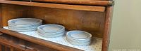 Stacks of dinner, salad, and bread plates inside cabinet