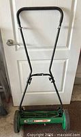 Front view of Scotts reel mower showing handle, deck, logo