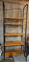 Full view of entire shelving unit showing five shelves and casters