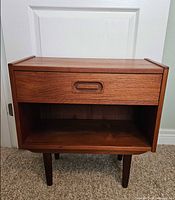 Front view showing drawer, open shelf, legs