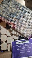 Box interior showing rolled wool bundles, partial canvas and instruction booklet