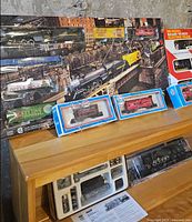 All items grouped on table including two boxed train sets, locomotive kit, and two boxed cars