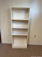 Front view of white Billy bookshelf showing four shelves, overall structure