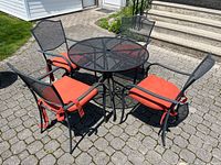 full patio set showing table and four chairs with cushions