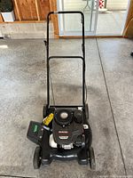 Full view of Yard Machines mower showing handle, deck and side chute