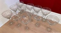 All twelve clear margarita glasses arranged upright showing uniform shape and condition