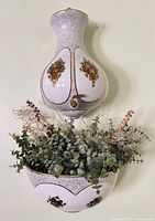 Full view of assembled two-piece porcelain lavabo wall fountain with faux greenery in basin