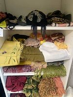 Shelved assortment of folded scarves in various colors and textures