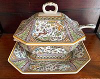 Tureen with lid seated on matching underplate displaying full painted pattern