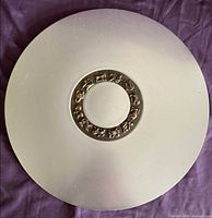 Full overhead view of round aluminum tray with brass zodiac ring
