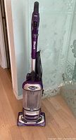 Front view of purple Shark Navigator upright vacuum showing dust cup, handle, base