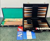 Both open cases side by side showing backgammon board, checkers, dice cups, rummy tiles, racks, and rule booklets