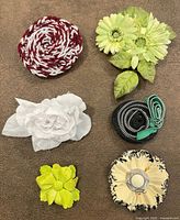 Front view of six assorted flower brooches
