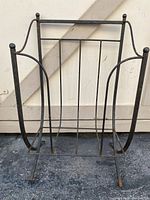 Full view of wrought iron magazine rack showing structure and finish