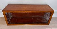 Front view of wooden shelf showing interior and sliding door track