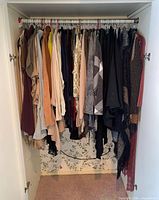 Closet view showing full assortment of hanging cardigans, jackets and sweaters
