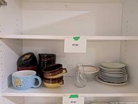 Shelf view showing plates, lacquer miso bowls, stoneware bowls, mug and carafe