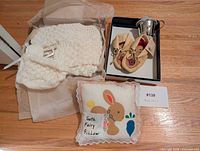 All four baby items grouped: sweater, moccasins, cup with lid, tooth fairy pillow