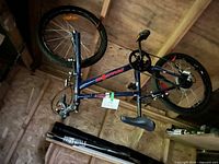 Full view of upside-down blue Falcon kid’s bicycle in storage