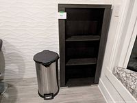 Bookcase and trash can side by side