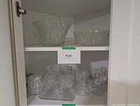 Cabinet showing both shelves with crystal bowls and assorted glassware