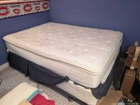 Double mattress stacked on box spring atop metal frame