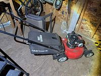 Left side view of Craftsman red push mower with bag attached